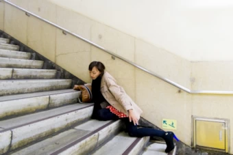 階段で転倒する女性