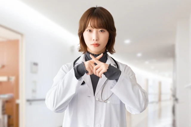 バツ印を示す女性