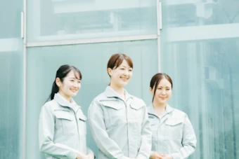 前を見る作業服の３人の女性